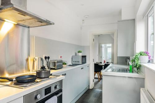 a kitchen with white counters and a stove top oven at Sleek 2BR city centre Pool table, Parking, Garden, Workspace, weekly sale in Nottingham