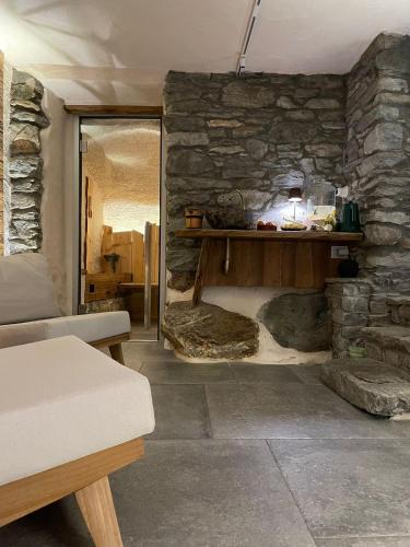 a living room with a stone wall with a table at Una piccola bomboniera in Gaby