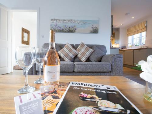 a bottle of wine sitting on a table in a living room at Gingerbread Cottage - Part of the The Bay Filey Holiday Village with pool, gym and direct beach access, pub, restaurant, tennis and meadows walks in Filey