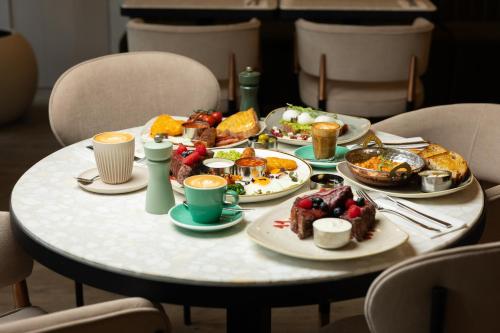 ロンドンにあるザ ライオン ＆ キー ホテルの朝食の食べ物が載ったテーブル