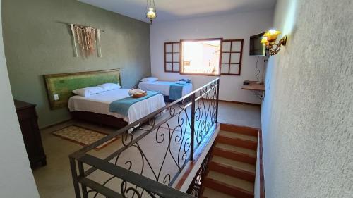 圣安娜杜里亚舒Casa Frida 400m do centro - Serra do Cipo的客房设有两张床和一个阳台。