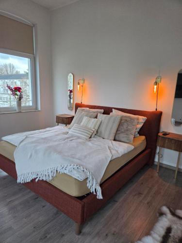 a large bed in a bedroom with a window at Kurparkloft in Bad Oeynhausen