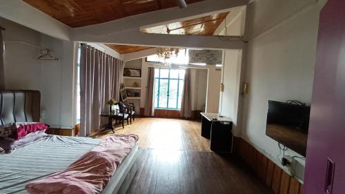 a bedroom with a bed and a tv in it at Dzükou Guest House in Kohīma