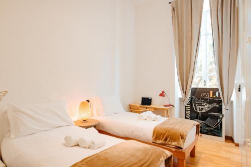 a bedroom with two beds and a window at Carlo Alberto CHARM & TERRACE in Turin