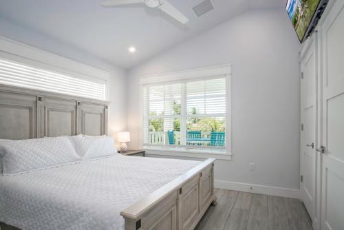 ein weißes Schlafzimmer mit einem Bett und einem Fenster in der Unterkunft Heart of Morada in Islamorada