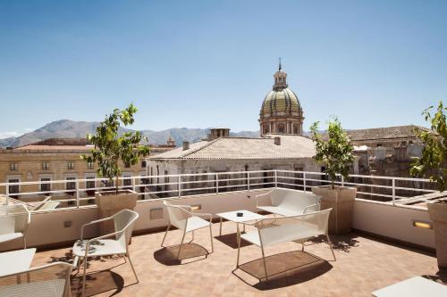 a balcony with a table and chairs on a roof at B&B Hotel Palermo Quattro Canti in Palermo