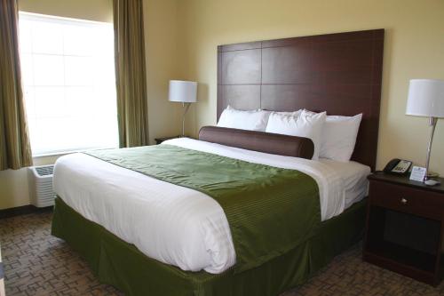 a hotel room with a large bed and a window at Cobblestone Hotel & Suites - Devils Lake in Devils Lake
