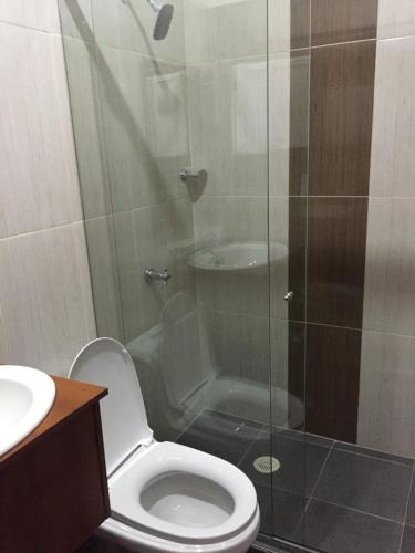a bathroom with a toilet and a glass shower at Hotel la Embajada Antioqueña in Cúcuta