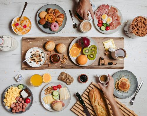 a table with a bunch of breakfast foods on plates at B&B Hotel Cremona in Cremona