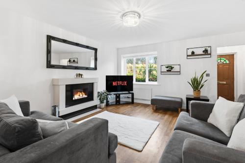 a living room with two couches and a fireplace at Stylish 3-Bed House in Newton-le-Willows - Private Parking & Garden in Newton-le-Willows