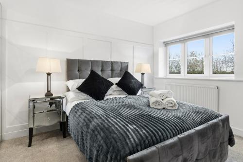 a bedroom with a large bed with a teddy bear on it at Stylish 3-Bed House in Newton-le-Willows - Private Parking & Garden in Newton-le-Willows