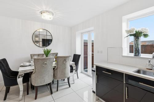 a kitchen and dining room with a table and chairs at Stylish 3-Bed House in Newton-le-Willows - Private Parking & Garden in Newton-le-Willows