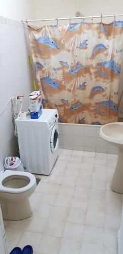 a bathroom with a toilet and a shower curtain at Men-only house in Khor Fakkan in Khor Fakkan