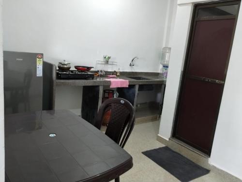 een kleine keuken met een tafel en een tafel en een tafel en een tafel bij Laxmi house in Arambol