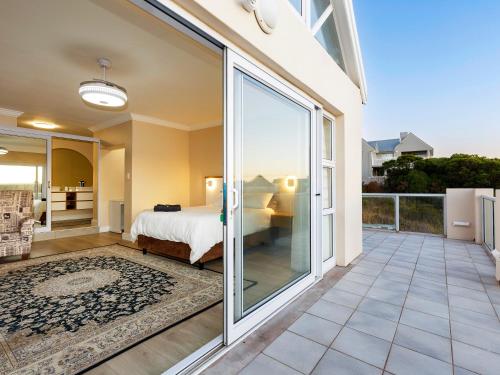 Un dormitorio con una cama y una puerta corrediza de vidrio. en Oppies Nest in Myburgh Park - Langebaan, en Langebaan