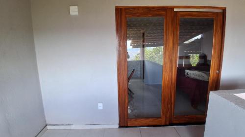 Una puerta de madera en una habitación con ventana en Chalé Lá Aurora, en Guaramiranga