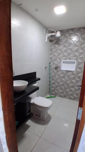 a bathroom with a toilet and a sink at Chalé Lá Aurora in Guaramiranga
