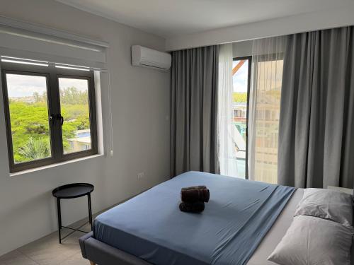 a bedroom with a bed with a bag on it at Top-Floor Modern 3BD Penthouse with Beautiful Mountain View Terrace - 5 min Walk to Beach in Flic-en-Flac