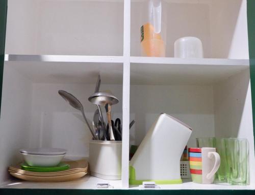 a white cabinet with dishes and utensils in it at Arcova Residences 2BR Apartment in San Carlos
