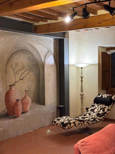 a living room with a couch and vases on a wall at Borgo La Valle in Palazzo del Pero