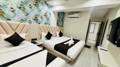 1 dormitorio con 2 camas y un perro en la cama en Hotel A One, en Jāmb