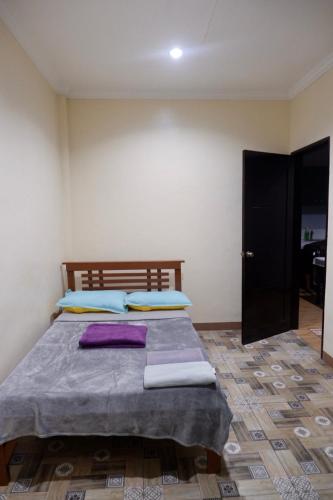 a bedroom with a bed with purple pillows on it at Arcova Residences 2BR Apartment in San Carlos