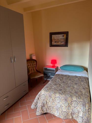 a bedroom with a bed and a red lamp on a table at Borgo La Valle in Palazzo del Pero