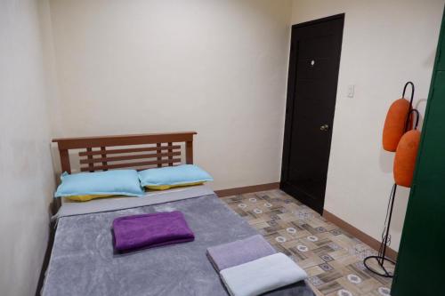 a bedroom with a bed with purple pillows at Arcova Residences 2BR Apartment in San Carlos