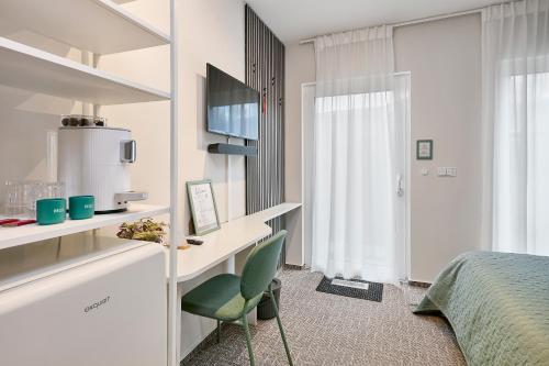 a bedroom with a bed and a green chair at Neubau - Citynah & Modern in Hamburg Niendorf in Hamburg