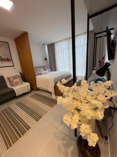 een slaapkamer met een bed en een tafel met bloemen bij Apartamento Milla 1 in Pomerode