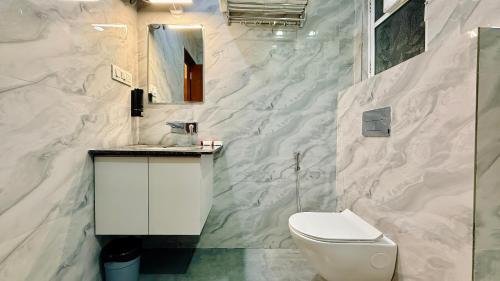 a bathroom with a white toilet and a sink at Hotel Mantri Ji in Ujjain