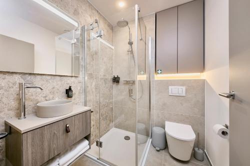 a bathroom with a sink and a toilet and a shower at Neubau - Citynah & Modern in Hamburg Niendorf in Hamburg