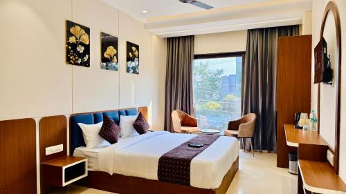a hotel room with a bed and a window at Hotel Mantri Ji in Ujjain