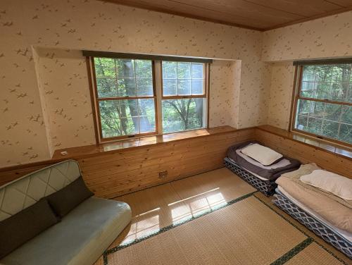 a room with a couch and a bed in it at Mountain chalet getaway at Fuji-Sanroku 富士山麓のシャレー風山荘 in Narusawa