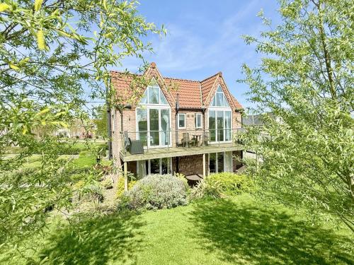 an old brick house with windows and a yard at Pearl & Spice Hideaways - 2 two bedroom cottages nearby - Part of the The Bay Filey Holiday Village with pool, gym and direct beach access, pub, restaurant, tennis and meadows walks in Reighton