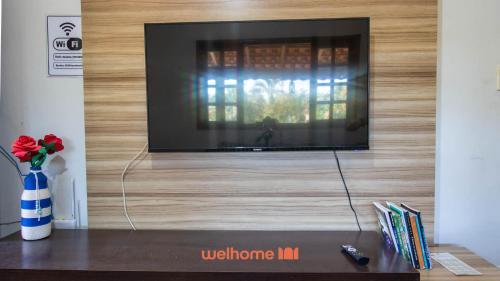 una TV a schermo piatto su una parete di legno di Sitio em Aracariguama com Piscina e Churrasqueira a Araçariguama