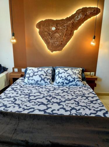 a bedroom with a bed with a rock on the wall at Surf Harbour Homestay in Los Abrigos