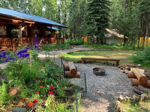 a garden with a bench and a table and flowers at Sven's Basecamp Hostel in Fairbanks