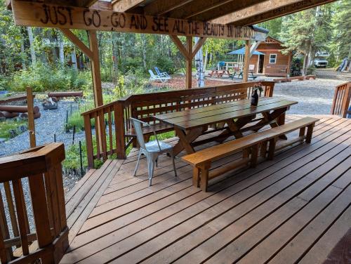 a wooden deck with a picnic table and benches at Sven's Basecamp Hostel in Fairbanks