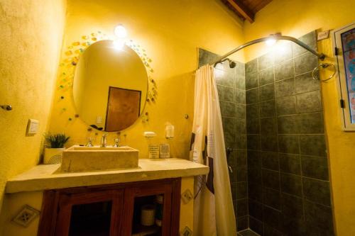 Un baño con lavabo, espejo y ducha. en Cabañas Atardeceres, en Capilla del Monte