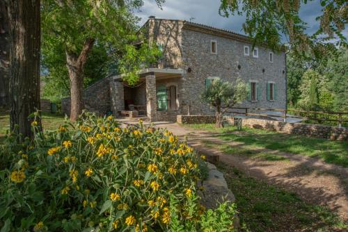 een stenen huis met gele bloemen ervoor bij Les Cezennes in Saint-Ambroix