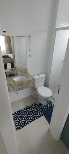 a white bathroom with a toilet and a sink at Apto ALTO PADRÃO com Churrasqueira, Cama Ortopedica e ar Condicionado 300m da praia acomoda 06 PESSOAS in Piçarras