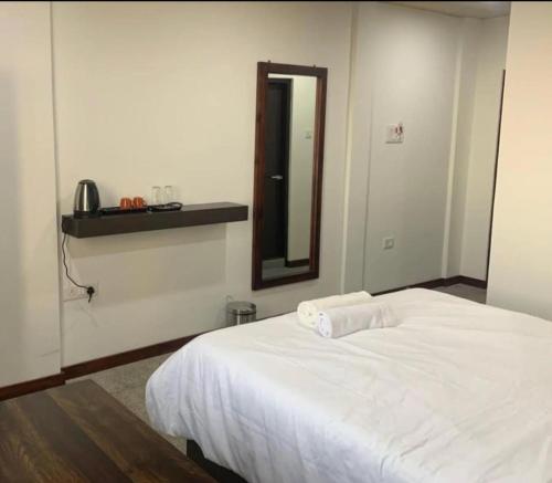 a bedroom with a white bed and a mirror at Serene haven in Kohīma