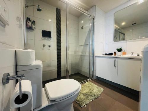 Central Melbourne 2BR Balcony Apartment في ملبورن: حمام ابيض مع مرحاض ودش