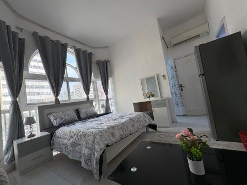 a bedroom with a bed and a large window at Lang Homes in Abu Dhabi