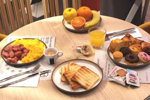 een tafel met borden ontbijt erop bij B&B Hotel Milano City Center Duomo in Milaan