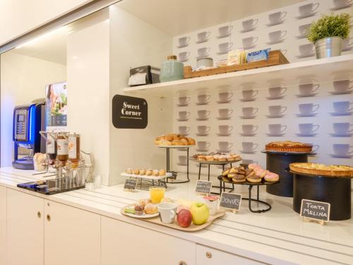 a bakery counter with various pastries and desserts on display at B&B Hotel Ravenna in Ravenna