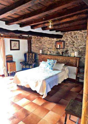 a bedroom with a bed and a stone wall at Casa Lucia in Mogarraz