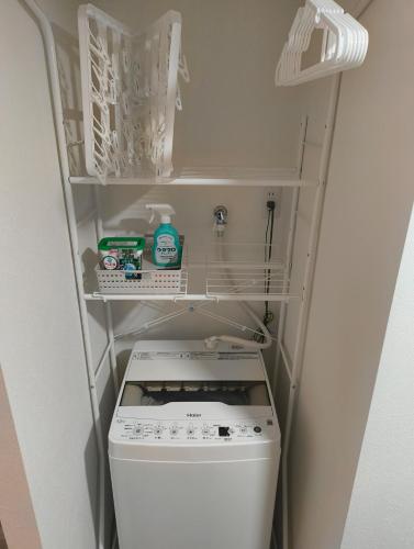 a small bathroom with a washer in a room at KamaKama Stay in Tokyo