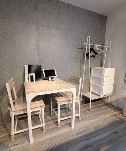 a table and chairs with a laptop computer on it at KamaKama Stay in Tokyo
